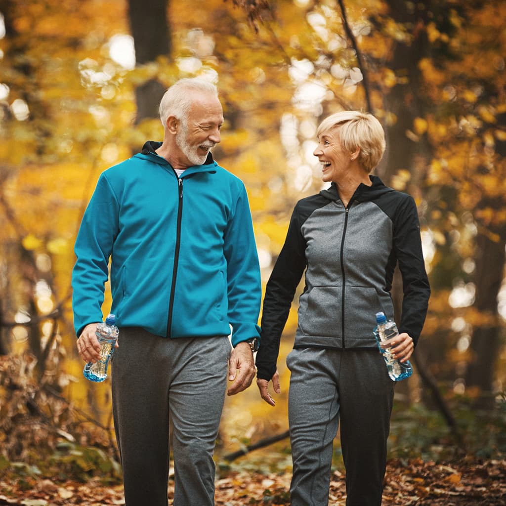 Frau und Mann spazieren im Herbst im Wald